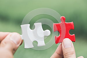 Business woman is trying to connect couple puzzle piece. Symbol of association and connection. Concept of business strategy