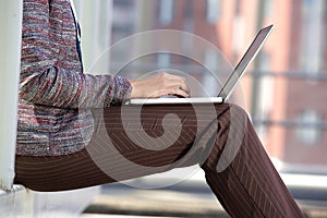 Business woman typing on laptop outside