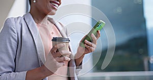 Business woman, typing on phone and coffee by office window for communication or networking. Closeup of female