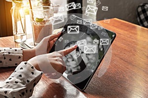 Business woman use tablet with email icons in work space.