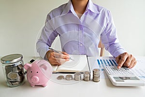Business woman used calculator and record account with pink piggy bank, step up growing business to success and saving