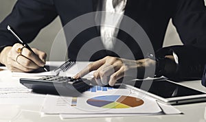 à¸ºBusiness woman using a calculator on the desk in the office accounting saving finance concept