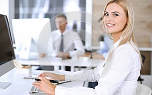 Business woman using computer at workplace in modern office. Secretary or female lawyer smiling and looks happy. Working