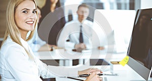 Business woman using computer at workplace in modern office. Secretary or female lawyer smiling and looks happy. Working