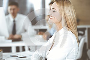 Business woman using computer at workplace in modern office. Secretary or female lawyer smiling and looks happy. Working