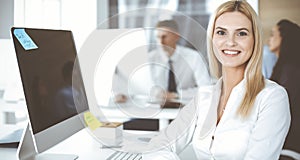 Business woman using computer at workplace in modern office. Secretary or female lawyer smiling and looks happy. Working
