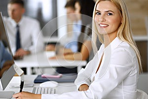 Business woman using computer at workplace in modern office. Secretary or female lawyer smiling and looks happy. Working