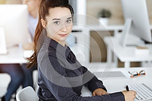 Business woman using computer at workplace in sunny office. Working for pleasure and success