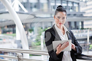 Business woman using digital tablet computer outside office. happy young beautiful girl working on social media outdoor over