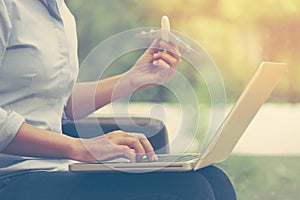 Business woman using laptop computer and holding airplane. travel concept