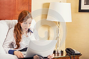 Business woman using laptop looking at computer screen blown away in stupor