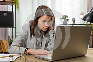 Business woman using laptop typing browsing bad news, fortune loss fails at home office workplace