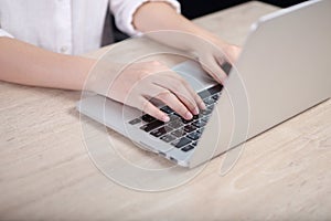 Business woman using laptop on wooden desk