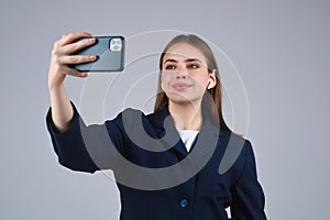 Business woman using phone and making video call. Girl make selfie with smart phone. Businesswoman with phone in studio