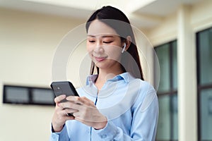 A business woman is using the smart phone while standing outside