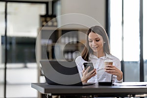 Business woman using smartphone for do math finance on wooden desk in office, tax, accounting, financial concept