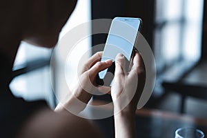 Business woman using smartphone during lunch in cafe.