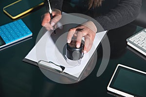Business woman using stamp on document