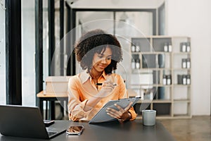 Business woman using tablet and laptop for doing math finance on an office desk, tax, report, accounting, statistics, and