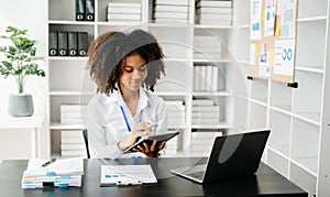 Business woman using tablet and laptop for doing math finance on an office desk, tax, report, accounting, statistics, and