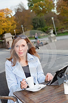 Business woman using tablet on lunch break.