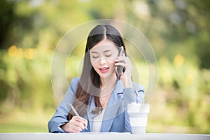 Business woman using tablet on lunch break in city park