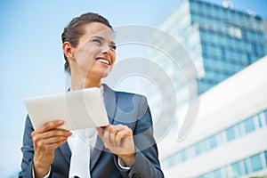 Business woman using tablet pc in front of office