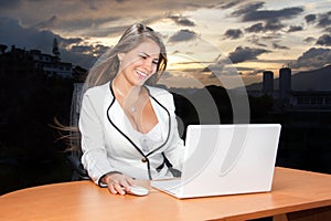 Business woman very happy looking laptop in the sunset