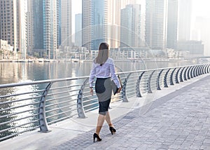 Business woman walking on a boardwalk.