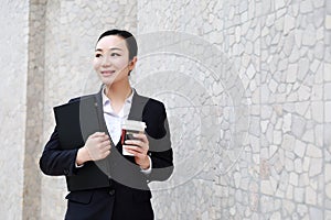 Business woman walking drinking coffee and Notebook computer