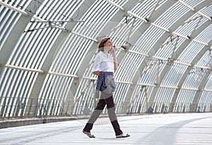 Business woman walking and talking on mobile phone