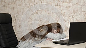 Business woman was weakened at work and fell asleep at a computer. A tired office worker sleeps on documents at her desk