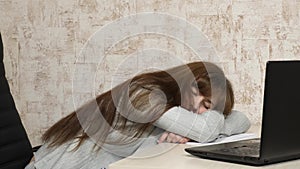 Business woman was weakened at work and fell asleep at a computer. A tired office worker sleeps on documents at her desk