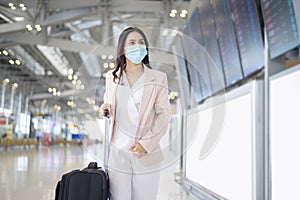 A business woman is wearing protective mask in International airport, travel under Covid-19 pandemic, safety travels, social