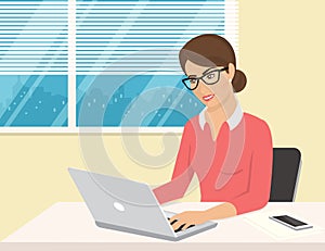 Business woman wearing rose shirt sitting in the office and working with laptop