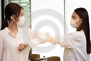 Business woman wering mask use elbow hello instead of hand shake