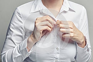 Business woman in white blouse unbuttoning shirt