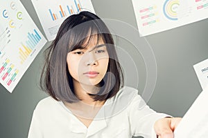 Business woman in a white dress is throw away a lot of paperwork and the documents are blown overhead.