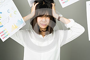 Business woman in a white dress is throw away a lot of paperwork and the documents are blown overhead.