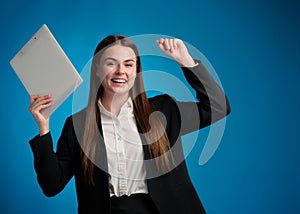 Business woman in white shirt and black suit standing and holding clipboard by her right hand and looking forward, rejoicing in