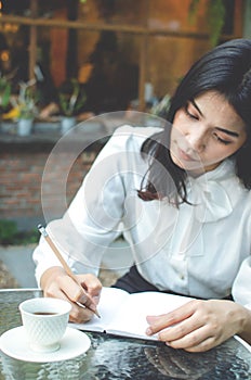 Business woman in white shirt working in cafe