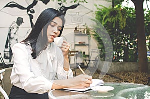 Business woman in white shirt working in cafe