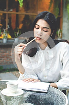 Business woman in white shirt working in cafe