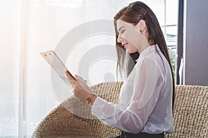 Business woman in white uniform reading report the commercial processes involved in promoting and selling and distributing a produ