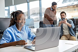 Business woman in wireless headset has video conference calling on laptop