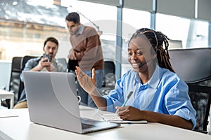 Business woman in wireless headset has video conference calling on laptop