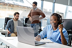 Business woman in wireless headset has video conference calling on laptop