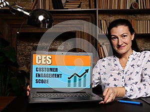 Business woman at work with financial reports  CES CUSTOMER ENGAGEMENT SCORE and a laptop