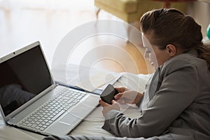 Business woman working on bed in hotel room