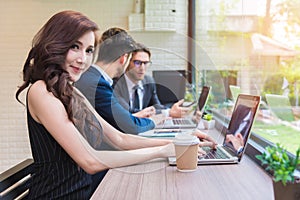 Business woman working with business team by laptop computer. Beauty and Technology concept. Smart lady and working woman theme.